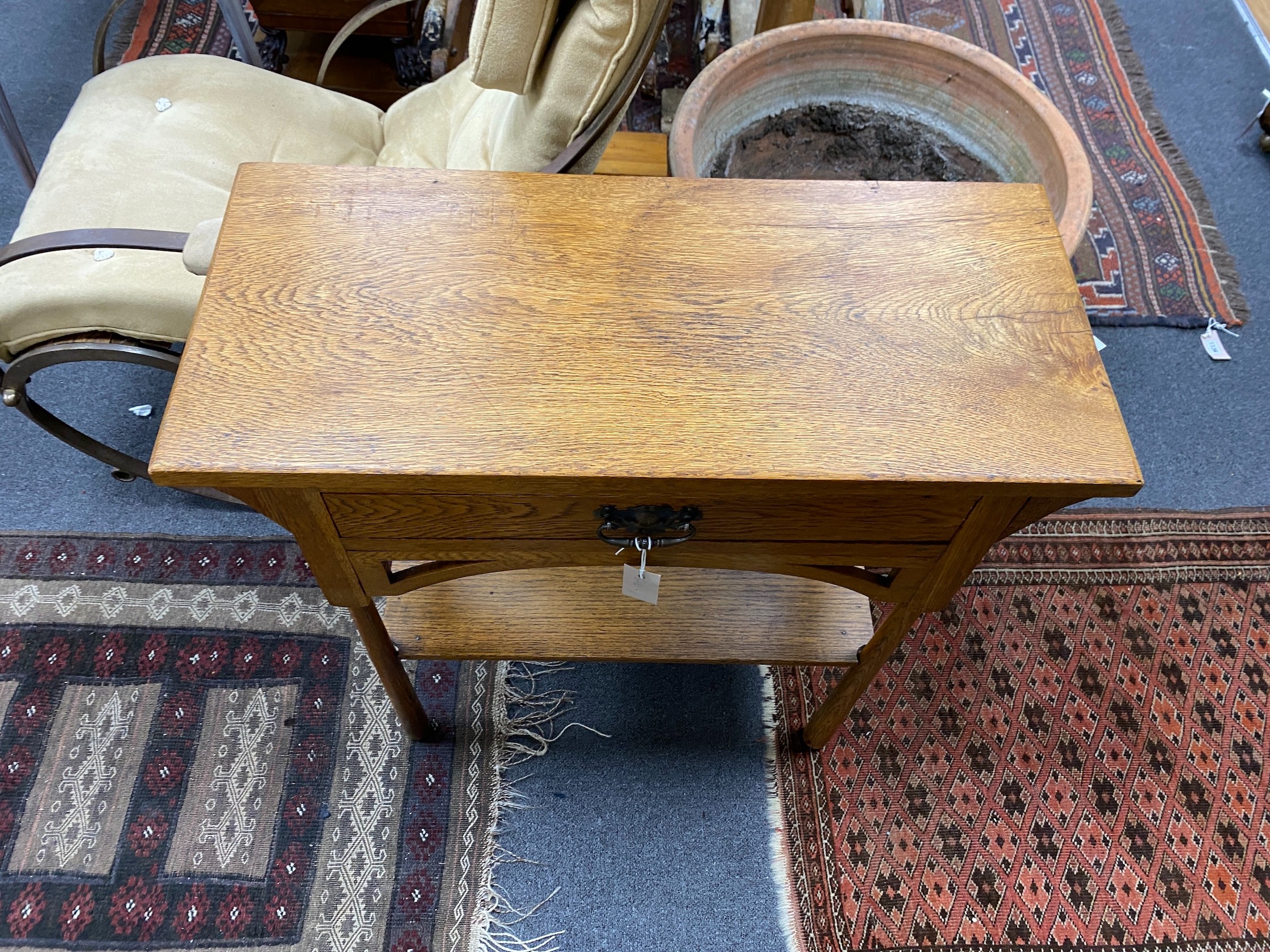An Arts & Crafts oak two tier side table, width 76cm, depth 33cm, height 77cm